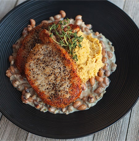 Pork Chops with Smashed Yellow Peas & Black Eyed Pea Gravy