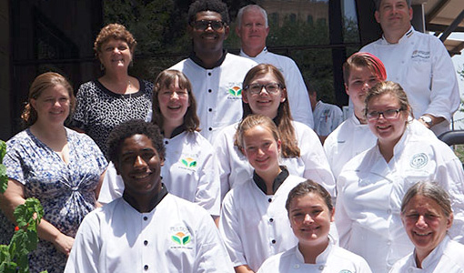 Contestants posing for a photo wearing Pulses chef aprons.